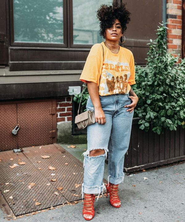 Edgy street style featuring an orange Beatles band tee, ripped mom jeans, strappy red heels, and a nude chain-strap purse.