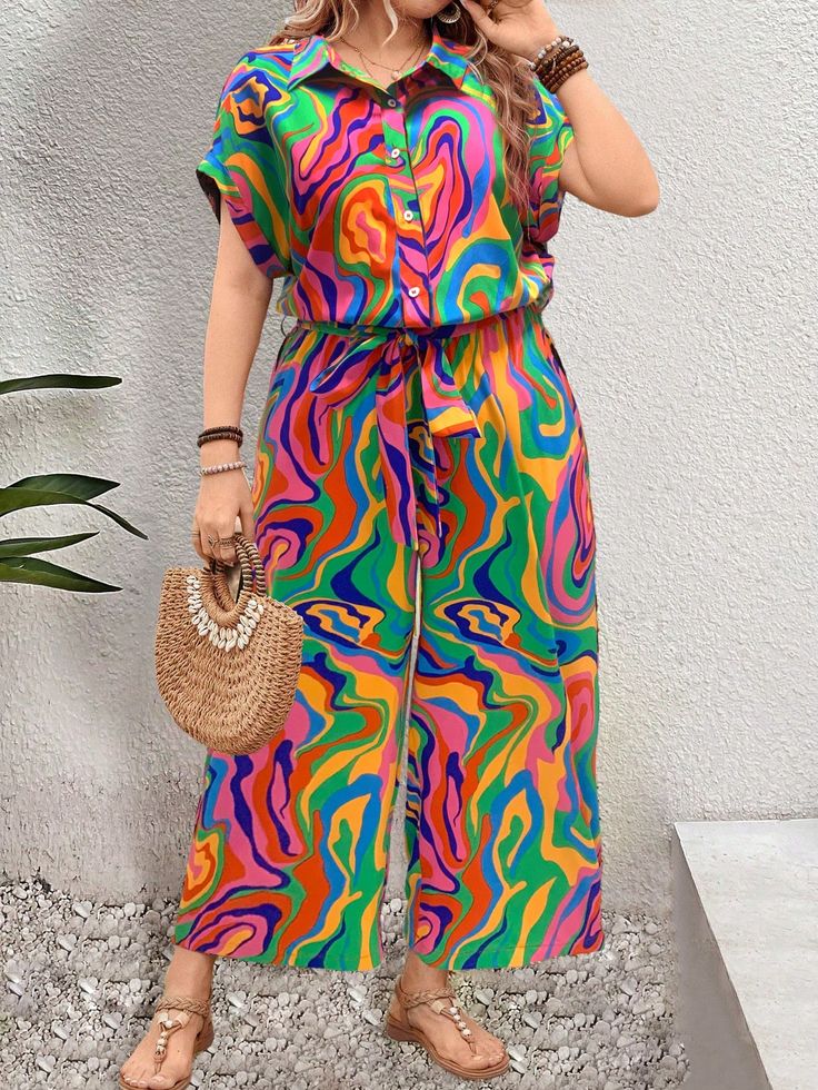 Woman wearing a vibrant multicolored swirl-patterned jumpsuit with wide legs, accessorized with a woven handbag and sandals.