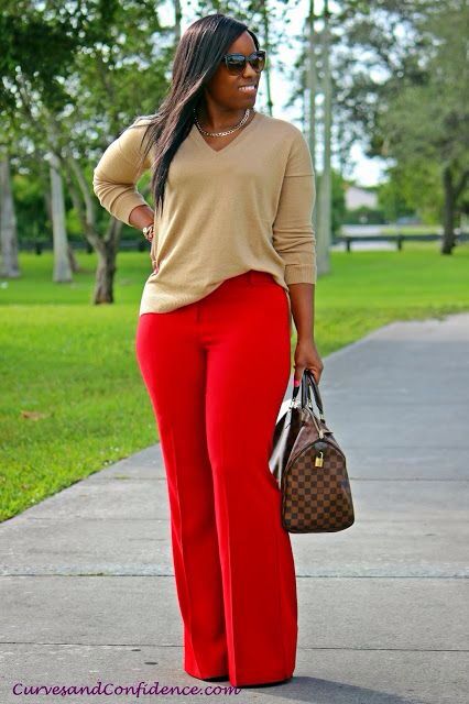 Powerful outfit idea for women over 40 featuring beige sweater, red wide-leg trousers, Louis Vuitton handbag, oversized sunglasses, and chain necklace for a bold chic look.